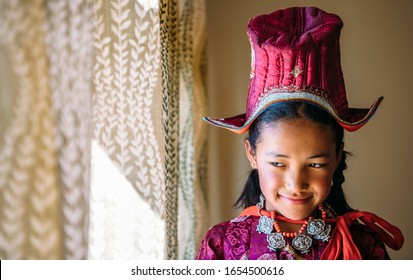 Portrait of a beautiful young girl in typical tibetan clothes with hat in Ladakh, Kashmir, India