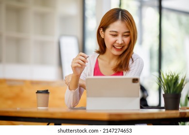 Portrait Of A Beautiful Young And Intelligent-looking Japanese Asian Woman Student Wearing A White Shirt And Pink Tracker Smiling As She Works On Her Laptop In A University Classroom.