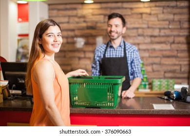 Portrait Of A Beautiful Young Latin Brunette Paying For Her Groceries At The Checkout Counter In A Store