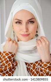 Portrait of beautiful young muslim arabian woman wearing white hijab looking at camera, close up