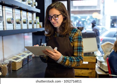 Portrait Of Beautiful Young Saleswoman Doing Inventory In A Retail Store Selling Coffee.