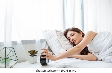 Portrait Of Beautiful Young Sexy Asian Woman Tried In The Morning Bedding Linen Mattress In White Bed Room Modern Apartment. Cute Asia Girl Stretching Snooze Alarm Awake From Sleep, Good Night Sleep