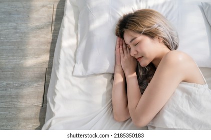 Portrait Of Beautiful Young Sexy Asian Woman With Attractive Smile Enjoy Fresh Soft Bedding Linen Mattress In White Bed Room Modern Apartment. Cute Asia Girl Sleep Resting, Good Night Sleep Concept.