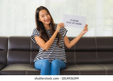 Portrait beautiful young show paper stay home on sofa in livingroom for save people from coronavirus or covid19 - Shutterstock ID 1814936399