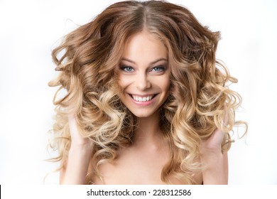 Portrait of beautiful young smiling girl with luxuriant hair curling. Health and Beauty.