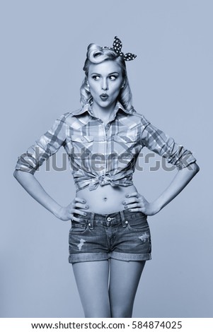 Portrait of beautiful young surprised woman, dressed in pin-up style. Caucasian blond model posing in retro fashion and vintage concept. Black and white.