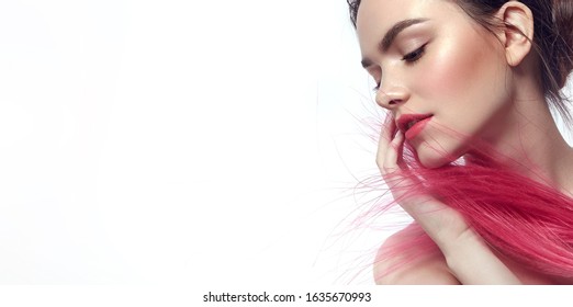 Portrait of a beautiful young tender romantic dark-haired girl on a white background. The face is covered with pink feathers