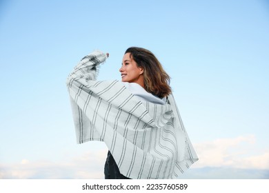 Portrait of beautiful young woman against blue sky