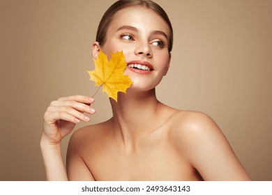 Portrait of beautiful young woman with autumn leafs. Healthy clean fresh skin natural make up beauty eyes - Powered by Shutterstock