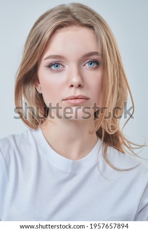Portrait of a beautiful young woman with blonde hair and natural make-up. Studio shot on a white background. Beauty industry.
