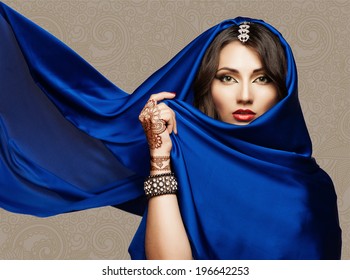 Portrait of a beautiful young woman in blue fabric