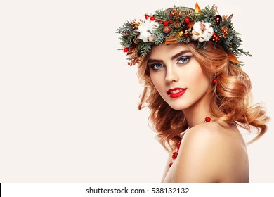 Portrait Of Beautiful Young Woman With Christmas Wreath. Beautiful New Year And Christmas Tree Holiday Hairstyle And Makeup. Beauty Girl Portrait Isolated On White Background. Colorful Makeup And Hair