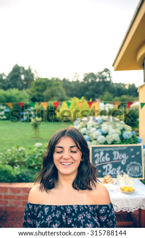 Young woman with closed eyes laughing over nature background