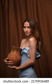 Portrait Of A Beautiful Young Woman With A Crock In Her Hands