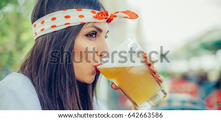 Portrait of beautiful young woman drinking beer and enjoying summer day