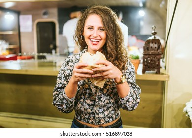 Portrait Of Beautiful Young Woman Eating Hamburguer In The Food Truck.