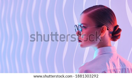 Portrait of a beautiful young woman in elegant glasses on a background with copy space. Glasses fashion. Business style. 
