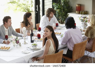 Portrait Of Beautiful Young Woman With Friends Having A Dinner Party At Home