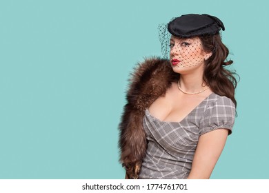 Portrait Of Beautiful Young Woman With Fur Boa Against Blue Background