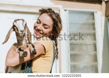 Portrait of a beautiful young woman with a goat