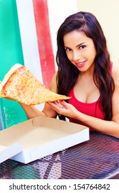 Portrait Of A Beautiful Young Woman Having A Large Slice Of Pizza. Vertical Shot.