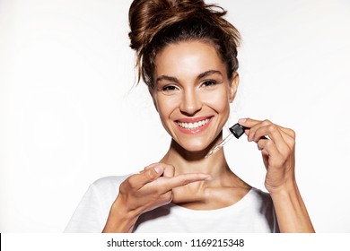 Portrait Of Beautiful Young Woman Holding Wetting Face Oil. Cute Girl With Natural Skin. Beauty Cosmetic Concept. Isolated On White Background