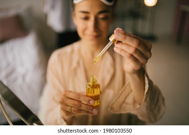 Portrait Of Beautiful Young Woman Holding Natural Face Oil. Beauty Cosmetic Concept.