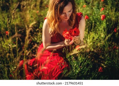 portrait of a beautiful young woman holding bouquet of red poppies.