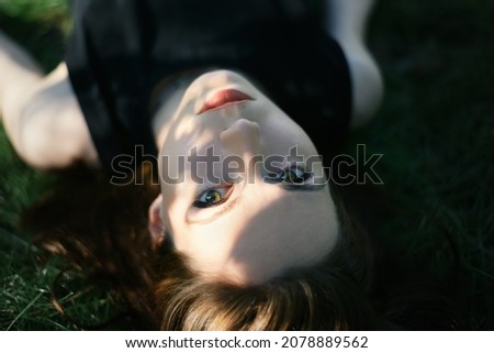 Similar – Frau in einem Blumenfeld bedeckt sich vor Sonnenlicht.