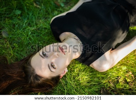 Similar – Frau in einem Blumenfeld bedeckt sich vor Sonnenlicht.