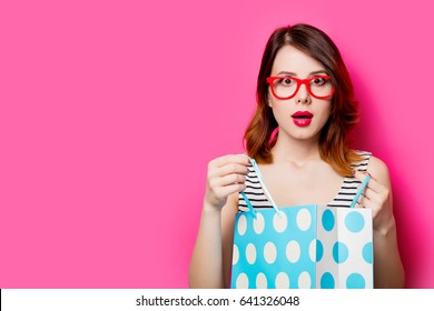 portrait of beautiful young woman with shopping bag on the wonderful pink studio background - Shutterstock ID 641326048