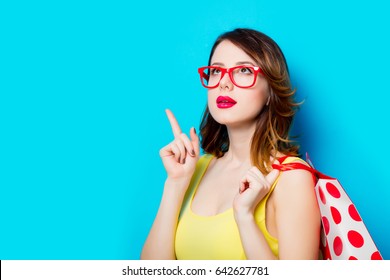 portrait of beautiful young woman with shopping bag on the wonderful blue studio background - Shutterstock ID 642627781
