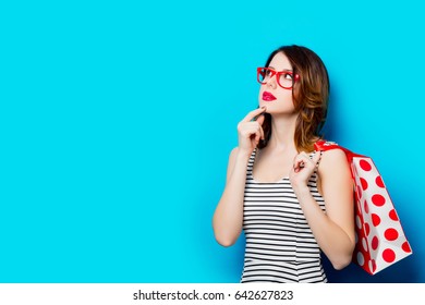 portrait of beautiful young woman with shopping bag on the wonderful blue studio background - Shutterstock ID 642627823