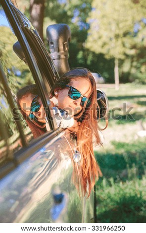 Similar – Happy young woman looking back through the window car