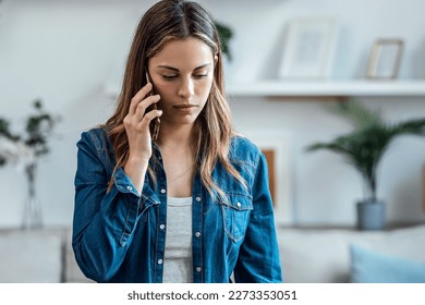 Portrait of beautiful young woman talking on the phone at home. - Powered by Shutterstock