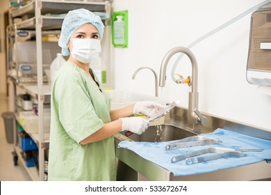 Portrait Of A Beautiful Young Woman Washing And Cleaning Medical Instruments In A Hospital