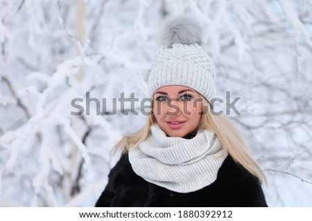 Portrait of a beautiful young woman in a winter forest