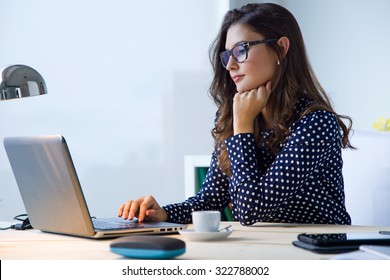 Portrait of beautiful young woman working with laptop in her office.