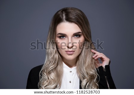Portrait of beautiful young women with perfect skin retouching. Blonde model with blue eyes. Photo studio portrait. Grey background. Horizontal.