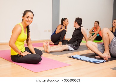 Portrait Of A Beautiful Young Yoga Instructor Relaxing After Giving A Class To A Large Group Of People