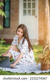 Portrait Of Beautifull Young Asian Woman Freelance Works On Laptop At Outdoor Workspace In The Garden.