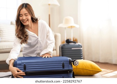Portrait of beauty asian traveler woman packing stuff and outfit clothes in suitcases travel bag luggage for summer holiday weekend tourist vacation trip at home. travel concept - Shutterstock ID 2258292767