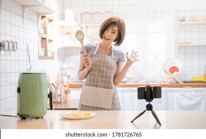 Portrait of beauty asian woman review cooking fry potato food, recording live video using air flyer smart device at home Online influencer girl vlog on social media marketing hobby and leisure concept - Powered by Shutterstock