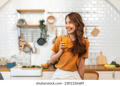 Portrait of beauty body slim healthy asian woman drinking glass of juice and orange.young girl preparing cooking healthy drink with fresh orange juice in kitchen at home.Diet concept.healthy drink - Powered by Shutterstock