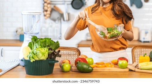 Portrait of beauty body slim healthy asian woman eating vegan food healthy with fresh vegetable salad in kitchen at home.diet, vegetarian, fruit, wellness, health, green food.Fitness and healthy food - Powered by Shutterstock