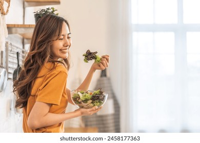 Portrait of beauty body slim healthy asian woman eating vegan food healthy with fresh vegetable salad in kitchen at home.diet, vegetarian, fruit, wellness, health, green food.Fitness and healthy food - Powered by Shutterstock