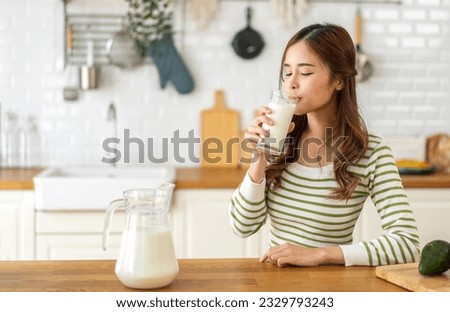 Portrait of beauty healthy asian woman smiling and having protein breakfast drinking and hold glasses of milk of fresh milk, nutrition,calcium and vitamin,dairy product in kitchen at home.Diet concept