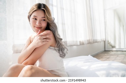 Portrait Of Beauty Smile Asian Woman Applying Lotion To Arm Shoulder Skin During Morning Routine. Cute Asian Girl Face. Skincare Body Lotion, Beauty Clinic Skincare Spa, Indoors Woman Lifestyle 