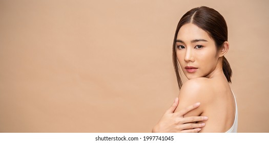 Portrait of beauty  smiling asian woman applying a lotion to her arm skin during her dressing up. Cute asian model girl. Skincare body lotion, beauty clinic skincare spa, woman lifestyle banner