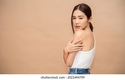 Portrait Of Beauty  Smiling Asian Woman Applying A Lotion To Arm Hand Touch Skin During Dressing Up. Cute Asian Model Girl. Skincare Body Lotion, Beauty Clinic Skincare Spa, Woman Lifestyle Concept